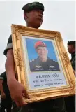  ??  ?? A Thai navy seal holds a picture of Saman Kunan