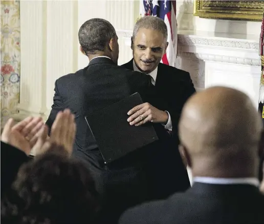  ?? Carolyn Kaster / the asociat ed press ?? Attorney General Eric Holder, right, embraces U.S. President Barack Obama at the White House on Thursday after the
president announced Holder was resigning after six years on the job. He is the first black U.S. attorney general.