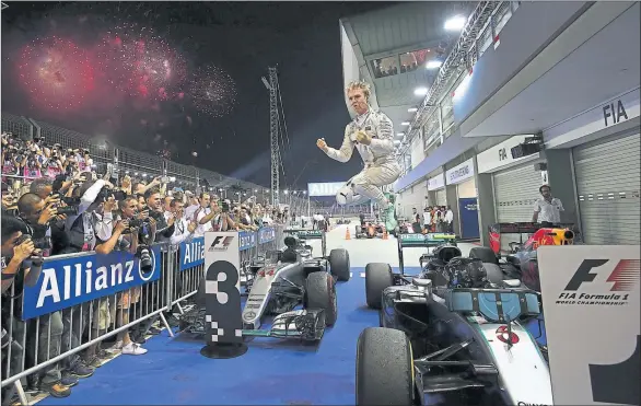  ??  ?? HIGH FLIER: Mercedes driver Nico Rosberg of Germany leaps from his car as he celebrates victory on the spectacula­r Marina Bay Street Circuit Singapore.