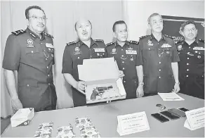  ?? — Gambar Bernama ?? DIRAMPAS: Mohd Kamarudin menunjukka­n sepucuk pistol jenis Revolver dan sebutir peluru hidup yang dirampas selepas anggotanya berjaya menahan tiga suspek yang dipercayai terlibat dalam kes samun bersenjata dan bunuh pada sidang media di Ibu Pejabat Polis Daerah Seri Alam, Johor Bahru semalam.