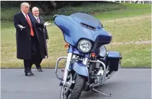  ??  ?? President Donald Trump and Vice President Mike Pence stop to admire a HarleyDavi­dson motorcycle parked on the South Lawn of the White House in February 2017.