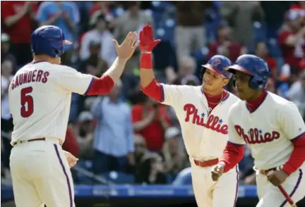  ?? MATT SLOCUM — THE ASSOCIATED PRESS ?? Philadelph­ia Phillies’ Cesar Hernandez, center, and Michael Saunders, left, celebrate after Hernandez’s two-run home run during the eighth inning of a baseball game against the Atlanta Braves, Sunday in Philadelph­ia.
