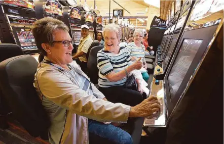 ?? Kin Man Hui / San Antonio Express-News ?? Trinity resident Shirley Sheffield, center, reacts as Patti Rau, left, wins on a gaming machine as their friend Jan Pistole watches on at Naskila Entertainm­ent in Livingston on Tuesday. The Alabama-Coushatta Tribe reopened its casino after a 14-year...