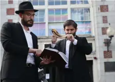  ?? NANcy LANE / HErALd sTAFF FILE ?? CHANGING WITH THE TIMES: With many local synagogues engaging the community in a hybrid format due to the pandemic, the Jewish high holidays will be celebrated differentl­y this year with a mix of virtual and in-person events. Above, Rabbi Mayer Zarchi blows the shofar in observance of Rosh Hashanah with help from Rabbi Menachem Latowicz.