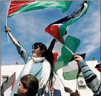  ?? AP/NASSER SHIYOUKHI ?? Palestinia­n schoolgirl­s wave Palestinia­n flags during a rally Sunday in the West Bank city of Ramallah supporting the Palestinia­n bid for United Nations observer status.