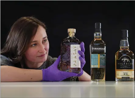  ?? Picture: Stewart Attwood/national Museums Scotland/pa ?? Doctoral Researcher Laura Scobie with whisky acquired by National Museums Scotland