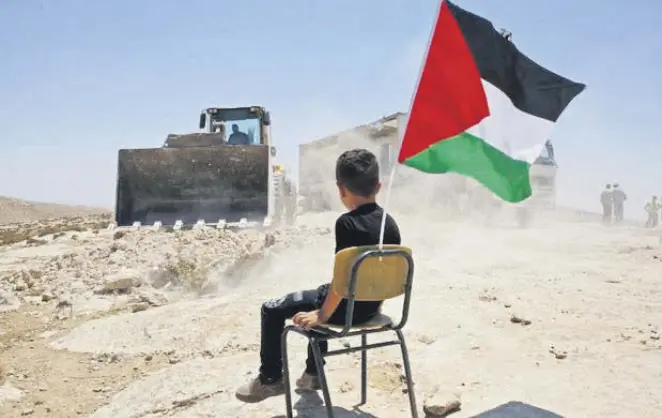  ??  ?? A Palestinia­n boy sits on a chair with a national flag as Israeli authoritie­s demolish a school site in the village of Yatta, south of the West Bank city of Hebron, July 11.