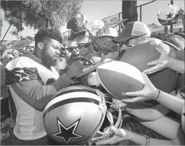  ?? Gus Ruelas Associated Press ?? COWBOYS running back Ezekiel Elliott, shown signing autographs in Oxnard last month, was accused by an ex-girlfriend of domestic violence, which he denies.