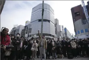  ?? (AP/Eugene Hoshiko) ?? Bystanders gather for an annual tribute that started at 2:46 p.m. for the victims of a 2011 disaster Monday in Tokyo.