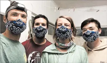  ?? MATT SAUNTER ?? Adapting quickly to the new normal, Matt Saunter, left, Matt Butschek, Naomi Worcester and Charlie Thomas wear masks after arriving in Honolulu following an eight-month expedition to Kure Atoll in the Northweste­rn Hawaiian Islands.