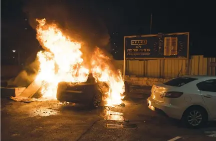  ?? (Roni Ofer/Flash90) ?? A CAR is set on fire during the Arab riots in Acre, May 2021.