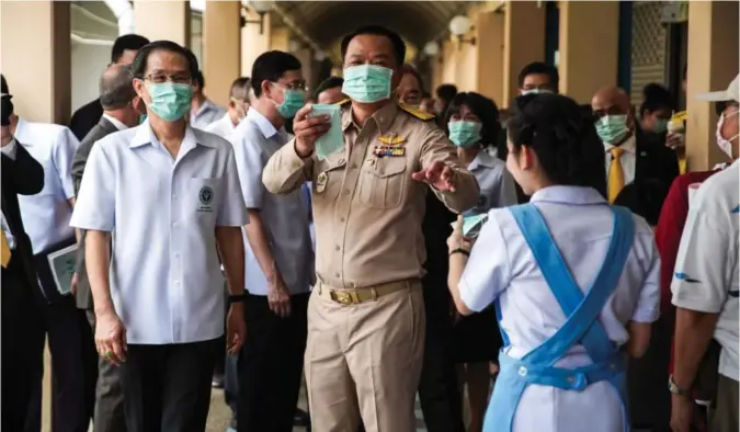  ?? ATHIT PERAWONGME­THA / X02943 ?? Thailands helseminis­ter og visestatts­minister, Anutin Charnvirak­ul, mistet besinnelse­n da han delte ut munnbind i Bankoks sentrum og en gruppe europeiske turister tilsynelat­ende avslo å benytte seg av tilbudet.