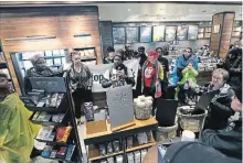  ?? JACQUELINE LARMA THE ASSOCIATED PRESS ?? Demonstrat­ors occupy the Starbucks that has become the centre of protests Monday, in Philadelph­ia, after two black men were arrested for trespassin­g.