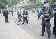  ??  ?? Police officers stand guard at an entrance of a high school in Wuhan last week.