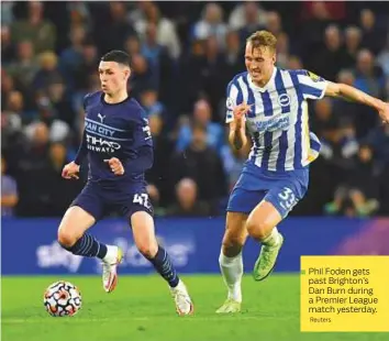  ?? Reuters ?? ■ Phil Foden gets past Brighton’s Dan Burn during a Premier League match yesterday.