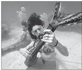  ?? Florida Keys News Bureau ?? Nicole Pacha (left) and Sarah Brunner pretend to play instrument­s at the Lower Keys Underwater Music Festival off Big Pine Key, Fla.