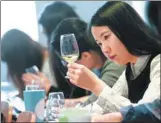  ?? PHILIPPE DESMAZES / AGENCE FRANCE-PRESSE ?? A Chinese student tastes and studies wine during a class at the Dijon Business School. Nearly one-third of the institutio­n’s 135 students are Chinese, willing to pay up to $14,000 for the expertise.