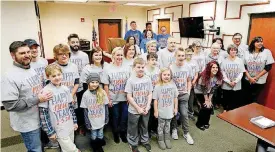  ?? [PHOTOS BY STEVE GOOCH, THE OKLAHOMAN] ?? Friends and family members pose for photos with Will Yeary as his adoption is finalized before Judge Cassandra Williams at the Oklahoma Juvenile Justice Center in Oklahoma City. They all wore “Happy New Yeary” T-shirts. BELOW: Judge Williams, left,...