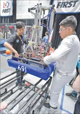  ?? Dan Watson/The Signal ?? Members of West Ranch High School’s Team 691 Julian Hope, left, and Demitri Duran lift their robot, which is named Jeffrey, into the arena during a robotics competitio­n held at Valencia High School in Valencia on Saturday.