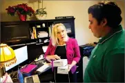  ?? AP PHOTO BY DAVID GOLDMAN ?? Gail Trauco, owner of The Pharmakon, left, talks with Jordan Rubio, her office manager and son, while working in her home office in Peachtree City, Ga., Monday. Trauco’s insurer is eliminatin­g her company’s policy known as a preferred provider...