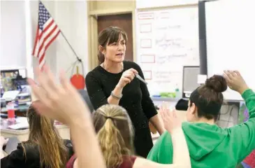  ?? Associated Press ?? n Teacher Natalie O’Brien, center, calls on students March 8 during a civics class called “We the People” at North Smithfield High School in North Smithfield, R.I. More states, including Arkansas, are requiring graduating high school students to know...