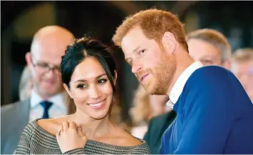  ?? BEN BIRCHALL/ AP ?? Britain’s Prince Harry talks to Meghan Markle as they watch a dance performanc­e by Jukebox Collective in the banqueting hall during a visit to Cardiff Castle, Wales. With Prince Harry and Meghan Markle’s May 19 wedding fast approachin­g, the fashion and...