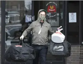  ?? TONY DEJAK — ASSOCIATED PRESS ?? Brian Turnquist delivers pizzas during the coronaviru­s pandemic April 16in Beachwood. Ohio has paid a record $227 million to more than 271,000 individual­s who filed for unemployme­nt in the past four weeks.