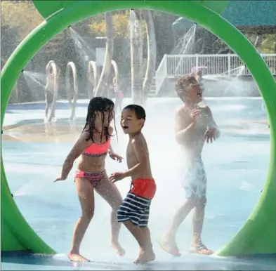  ?? PETER LEE, RECORD STAFF ?? Kinlee Nguyen, left, and brother Kayden, centre, and Jaedyn Adeniyi play in the Lions Lagoon splash pad in Waterloo on Friday.