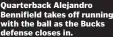  ??  ?? Quarterbac­k Alejandro Bennifield takes off running with the ball as the Bucks defense closes in.