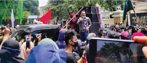  ?? LUDRY PRAYOGA/JAWA POS ?? BERGEJOLAK: Ketua DPRD Gresik M. Abdul Qodir menerima peserta aksi yang menolak UU tentang Cipta Kerja di depan gedung dewan kemarin.