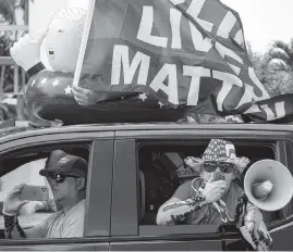  ?? CARL JUSTE cjuste@miamiheral­d.com ?? Pro-Trump supporters caravan westbound on NW 154th Street in Miami Lakes, making their feelings known to Black Lives Matter demonstrat­ors.