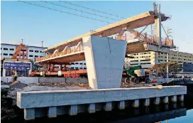  ?? [PEDRO PORTAL/ THE MIAMI HERALD VIA AP] ?? This March 10 photo shows the main span of the a pedestrian bridge being positioned to connect the city of Sweetwater to Florida Internatio­nal University near Miami. The 950- ton new bridge collapsed Thursday over several cars causing fatalities and...
