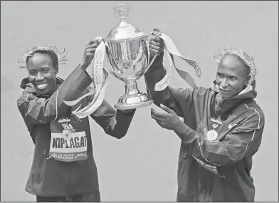  ?? Associated Press ?? Boston Marathon champs: Edna Kiplagat, left and Geoffrey Kirui, both of Kenya, hold a trophy together after their victories in the 121st Boston Marathon on Monday in Boston.