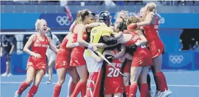  ?? ?? Maddie Hinch (in yellow keeper’s jersey) is at the centre of the celebratio­ns as GB claim hockey bronze in Tokyo
Picture from GB Hockey