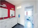  ?? TANYA COLLINS DESIGN/GORDON KING PHOTOGRAPH­Y ?? Red tiles in this children’s bathroom makes the vanity area the focal point and creates a playful mood.