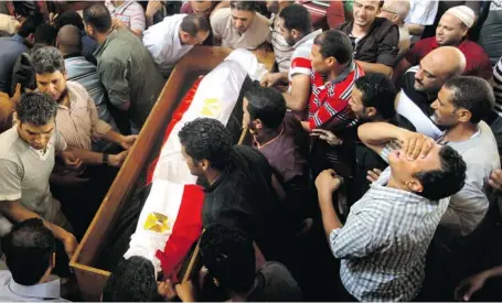  ?? AMR NABIL/THE ASSOCIATED PRESS ?? Supporters of Egypt’s ousted president Mohammed Morsi carry the coffin of their colleague who was killed during Wednesday’s clashes, in Amr Ibn AlAs mosque before funeral prayers in Cairo Friday, a day when civilians engaged in running street battles...