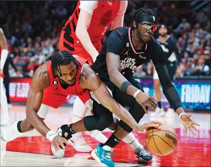  ?? ?? Portland Trail Blazers forward Justise Winslow, (left), and Los Angeles Clippers guard Reggie Jackson reach for the ball during the second half of an NBA basketball game in Portland, Ore. (AP)