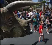  ?? LIZ MOUGHON / LOS ANGELES TIMES ?? Spectators take photos of the trisaurus “Juliet” at Jurassic Park at Universal Studios Hollywood in Universal City on July 17.