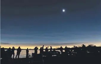  ?? ?? Personas provistas de telescopio­s y cámaras observan el eclipse de sol en Quebec, Canadá. AFP