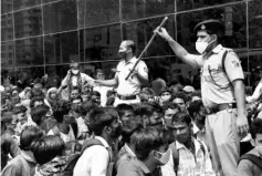  ?? PHOTO: REUTERS ?? Policemen asking people to sit at the entrance of Lokmanya Tilak Terminus railway station, amid the spread of Covid infections in Mumbai