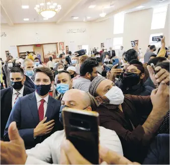  ?? THE CANADIAN PRESS ?? Community members at the Hamilton Mountain Mosque take photos of Prime Minister Justin Trudeau after he spoke to the congregati­on on Tuesday.