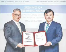  ?? ?? OOi (right) and UOB Kay Hian managing director David Lim Meng Hoe is seen during ECA’s underwriti­ng agreement with UOB Kay Hian.