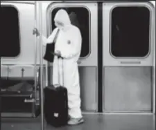  ??  ?? A woman wears personal protective equipment as she rides the air train at John F Kennedy Internatio­nal Airport in New York yesterday. (Reuters photo)