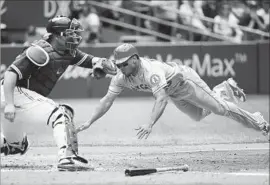  ?? Tom Szczerbows­ki Getty Images ?? THE ANGELS’ Ben Revere scores on a sacrifice fly during the ninth inning Saturday. Revere’s double in the inning helped the Angels overcome a 5-3 deficit.