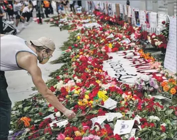  ?? Jay L. Clendenin Los Angeles Times ?? A MAN lays a rose at the Hall of Justice in downtown Los Angeles during a protest Friday in support of Black Lives Matter. The LAPD is facing increased criticism over how it has handled some of the protests.