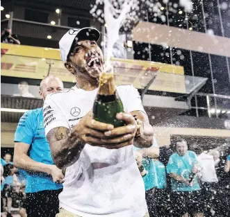  ?? LARS BARON/GETTY IMAGES ?? Race winner Lewis Hamilton celebrates with his team after the Abu Dhabi Formula One Grand Prix at Yas Marina Circuit on Sunday. He is contracted to Mercedes for the next two years, giving him a realistic chance of matching Michael Schumacher’s F1 record of 91 GP wins.