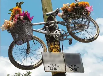  ?? Foto: Rainer Hagenbusch, dpa ?? Mit einem weißen Fahrrad an einem Strommast und Blumen wird in San Cristóbal de las Casas an die beiden getöteten Fahrrad fahrer erinnert.