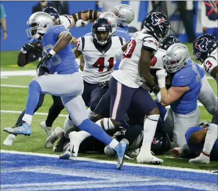  ?? DUANE BURLESON — THE ASSOCIATED PRESS ?? Detroit Lions running back Adrian Peterson breaks through the Houston Texans defense for a 1-yard touchdown run during the first half of Thursday’s game in Detroit.