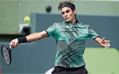  ?? — AP ?? Unstoppabl­e: Roger Federer returns a shot to Juan Martin del Potro in the third round of the Miami Open at Key Biscayne, Florida, on Monday.