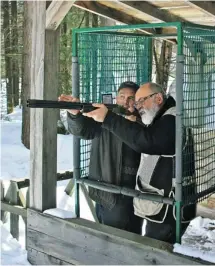  ?? OXANA SAWKA ?? The sporting clays course at Fairmont Kenauk has nine stations in a woodland setting. On a March day, instructor Michel Touchette, left, tells Peter Johansen how to line up his shotgun at the Woodcock station, where targets appear in three different...